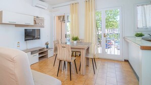 Una cocina moderna con comedor, televisor y vistas al exterior.
