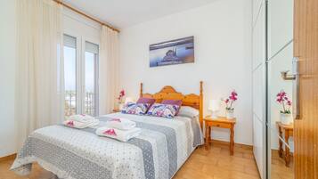 Een netjes ingerichte slaapkamer met een bed, een nachtkastje en een schilderij aan de muur.