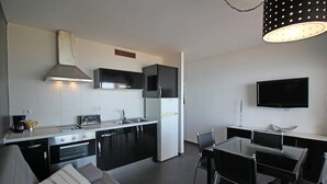 A modern kitchen with a dining area, including a sofa and chairs.