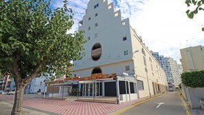 Un edificio moderno con un diseño arquitectónico único, que presenta un gran ventanal circular y un área de entrada techada.