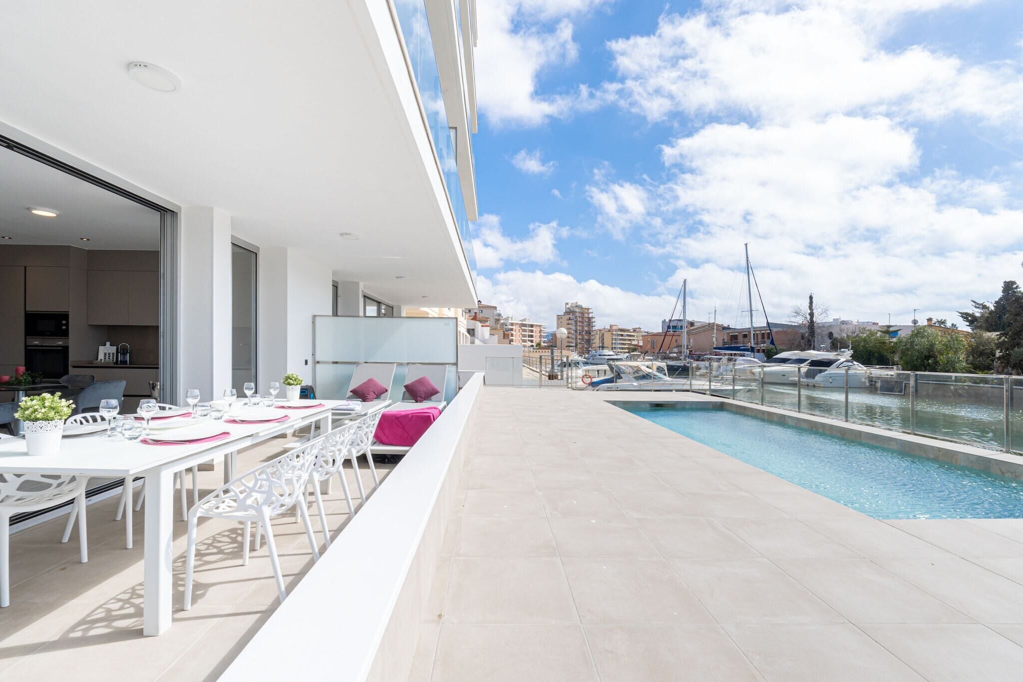A rooftop terrace with a pool, dining area, and city view.
