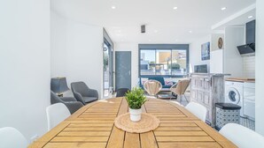 A modern kitchen with a wooden table, chairs, and a potted plant. - Villa in Empuriabrava with Private Pool (Empuriabrava)