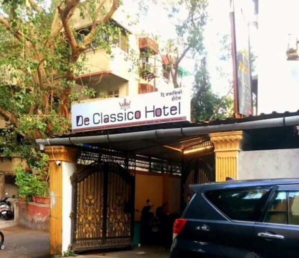 The entrance to De Classico Hotel with a gated entrance and a sign above. - De Classico Residency (Ayodhya)