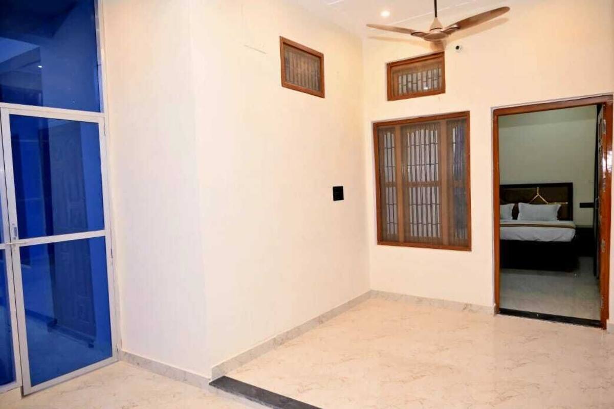 A room with a ceiling fan, a bed with a headboard, and a sliding glass door.