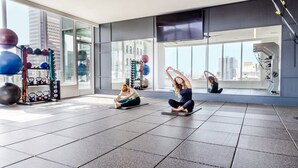 A spacious indoor gym with large windows, exercise equipment, and a city view. - Penthouse High-rise Ocean City Views (San Diego)