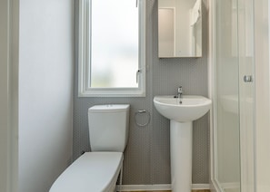 Une salle de bain avec des toilettes, un lavabo et une fenêtre.