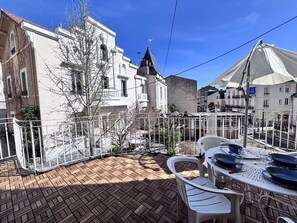 A courtyard with a brick floor, white chairs, and a table set for dining. - Intermezzo - 1 bedroom - Terrace (Châtel-Guyon)