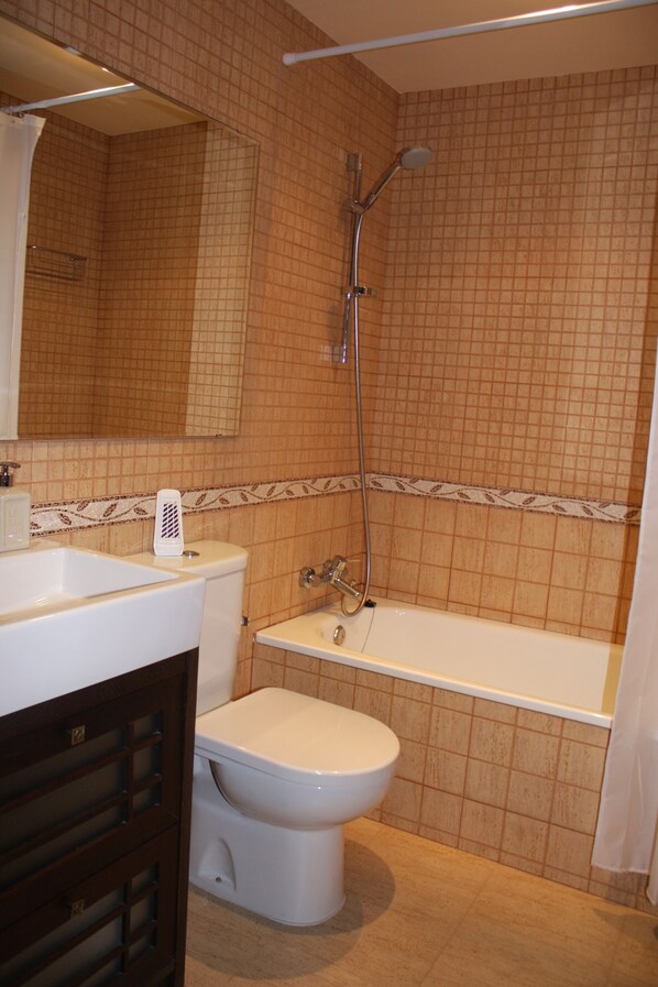 A bathroom with a toilet, sink, and bathtub.
