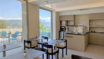 Una cocina moderna con una vitrina de vidrio, armarios de madera y vistas a montañas.