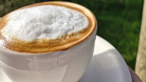A cup of coffee with a creamy foam top, held in a white cup and saucer. - Mavriya (Ezine)