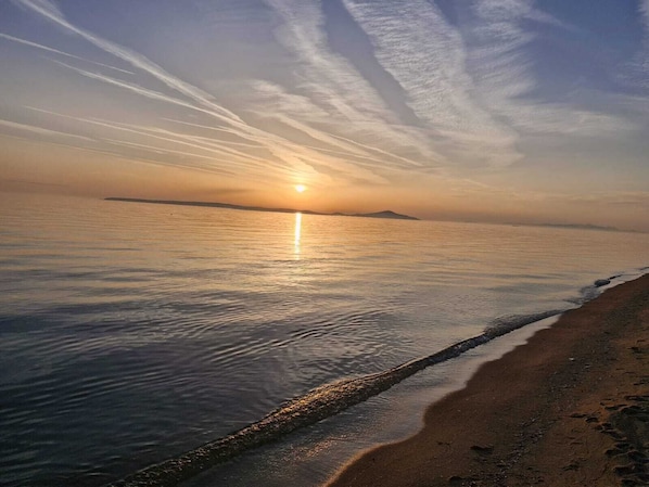 Ranta lähistöllä, aurinkotuoleja, aurinkovarjoja