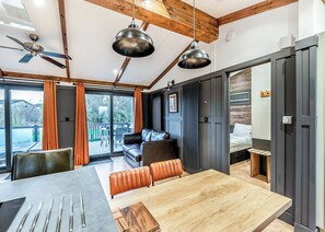 Ein modernes Interieur mit Essbereich, einer Couch und einem Deckenventilator.