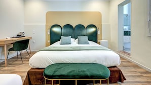 Una habitación de hotel moderna con una cama grande, un escritorio y una silla.