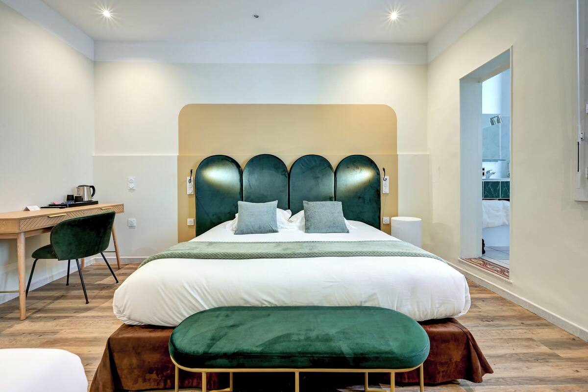 Une chambre d’hôtel moderne, dotée d’un grand lit, d’un bureau et d’une chaise.