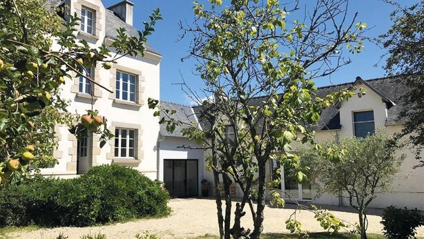 Une maison à deux étages avec un jardin à l’avant.