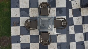 A checkered outdoor seating area with four chairs and a table. - Fillow Casa Hills (Narendra Nagar)