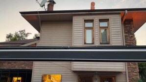 A two-story house with a chimney, a satellite dish, and a stone facade. - Villapark (Bartin)