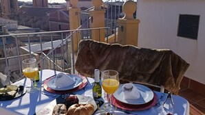 Una tavola imbandita per la colazione con vista sulla città, che include edifici a cupola e cielo sereno.