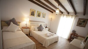Ein Schlafzimmer mit zwei Betten, einem Nachttisch, einer Lampe und einem Holztisch.