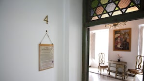 A room with a wooden desk, two chairs, a painting on the wall, and a number '4' on the wall.