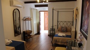 A hotel room with two beds, a glass table, a hanging chair, and a wardrobe. - LARGE TWIN ROOM WITH PRIVATE TERRACE (Cuevas de Almanzora)