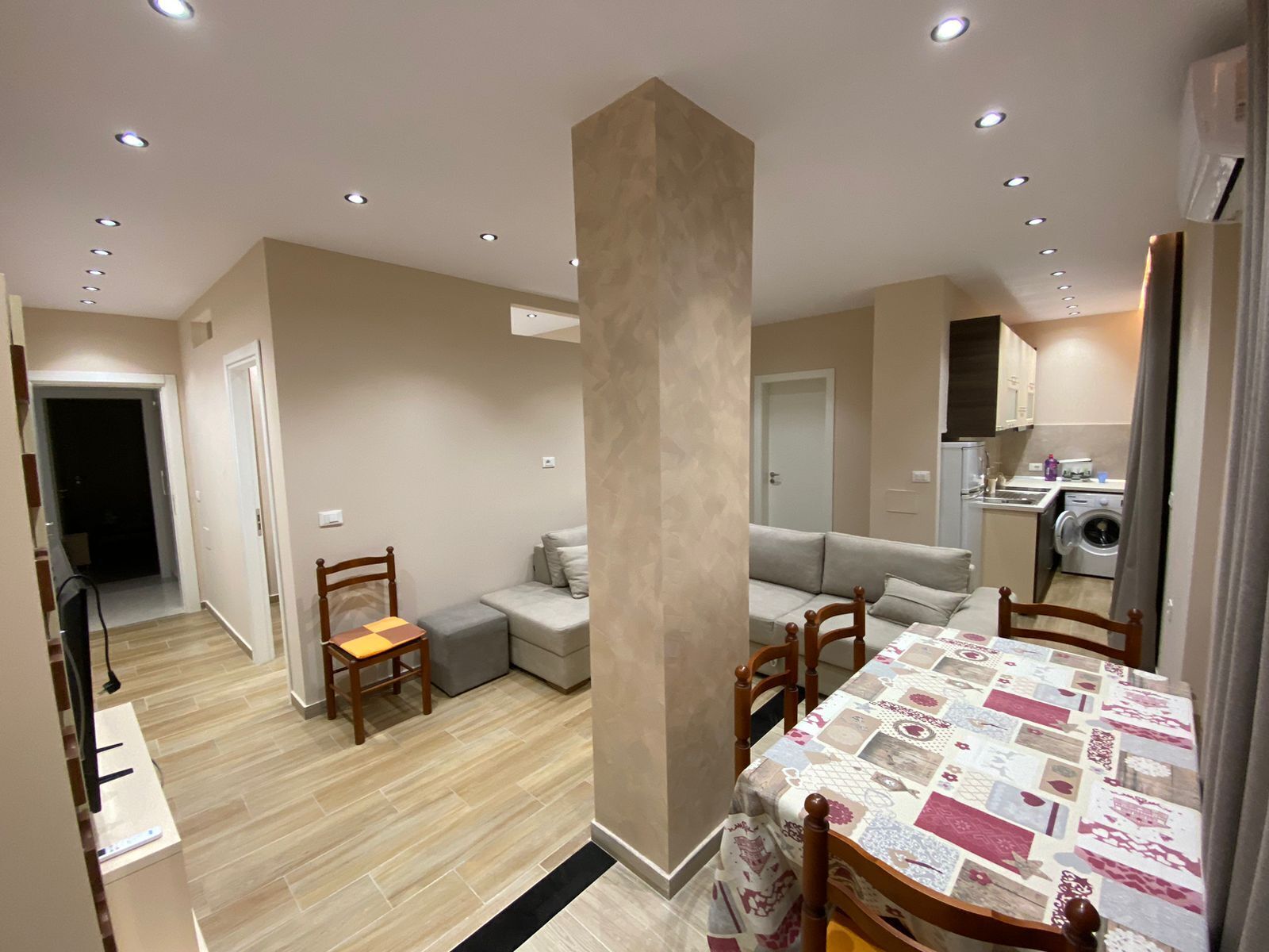 Un appartement moderne comprenant un coin repas, un canapé, une cuisine et un espace buanderie.