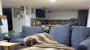 A living room with a blue sofa, a wooden coffee table, and a beige blanket. - Mary House (Scauri)