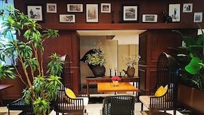 A dining area with a wooden table, chairs, and potted plants. - Moon River Puyue Hotel (Tongzhou)