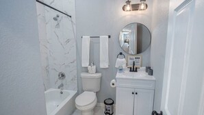 A bathroom with a bathtub, toilet, and sink.