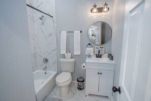 A bathroom with a bathtub, toilet, and sink.
