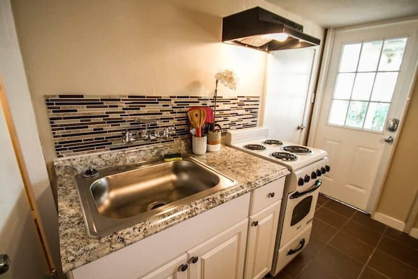 Horno, placa de cocina, cafetera o tetera y utensilios de cocina