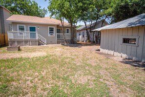 A residential area with two houses, one with a porch and a small shed.