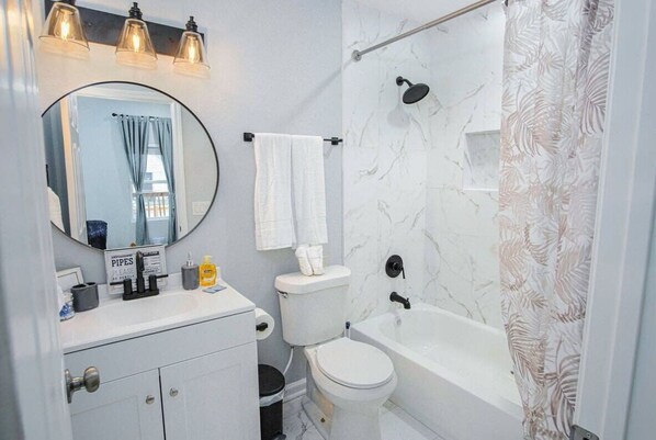 Un bagno con WC, lavandino, specchio e doccia.