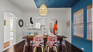 A dining area with a wooden table, clear chairs, and a hanging light fixture. - Gorgeous Artistic Fully Fenced Home Near Downtown (San Antonio)