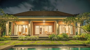 A modern house with a swimming pool, large windows, and a well-maintained garden. - Kesuma Inn Private Villa (Ubud)