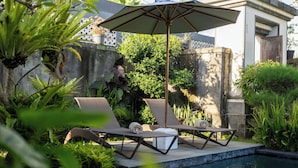 A poolside area with lounge chairs and a canopy. - Kesuma Inn Private Villa (Ubud)