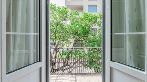 A view through a window with a metal railing, a tree, and a building in the background. - Close to the Center of Lugano (Sestante 2) (Viganello)