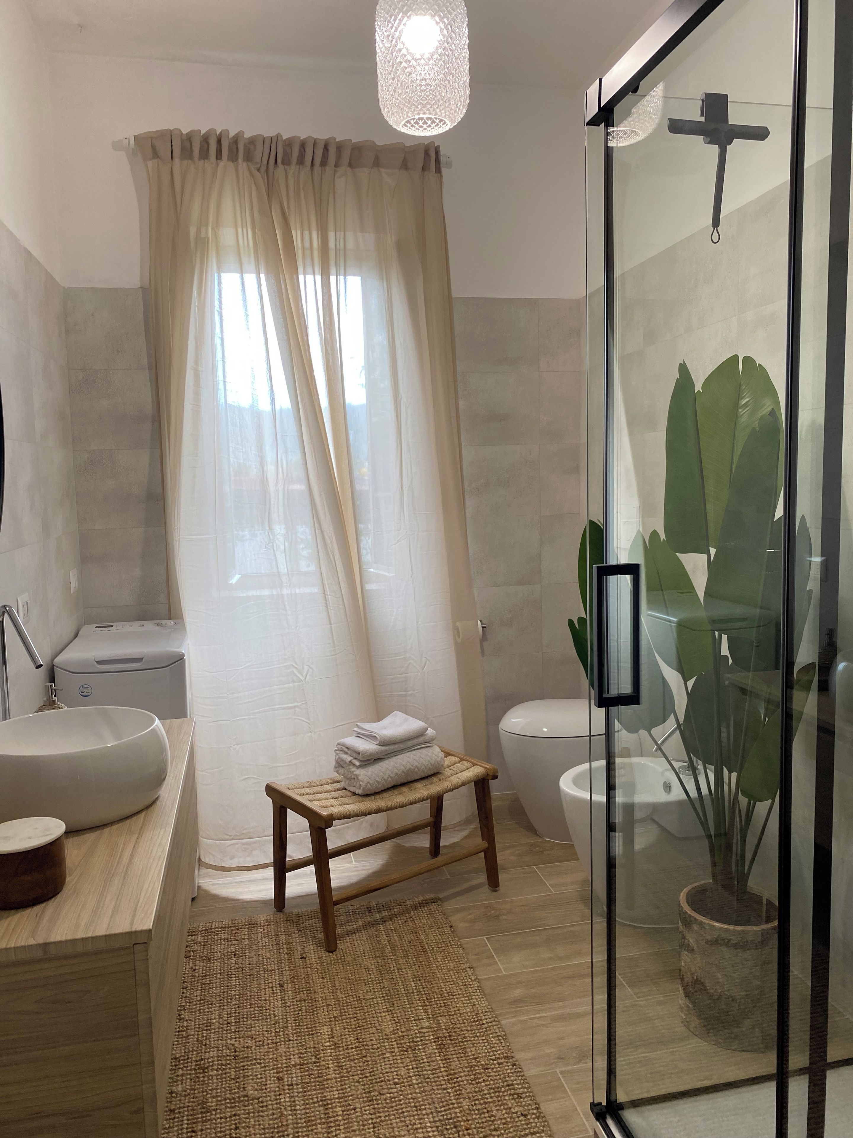 Une salle de bain moderne avec une douche à parois de verre, une baignoire sur pieds, des toilettes et un lavabo.