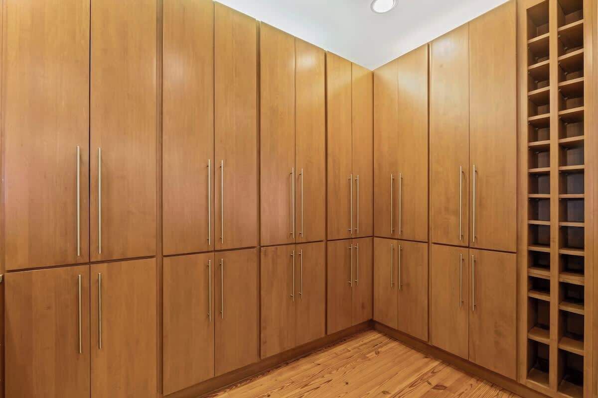 Un angolo di stanza con armadietti in legno e una libreria a muro.