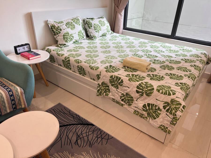 Une chambre à coucher bien rangée, avec un lit, une petite table ronde et une chaise.