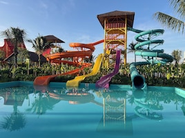 Um parque aquático com várias escorregas e uma piscina.