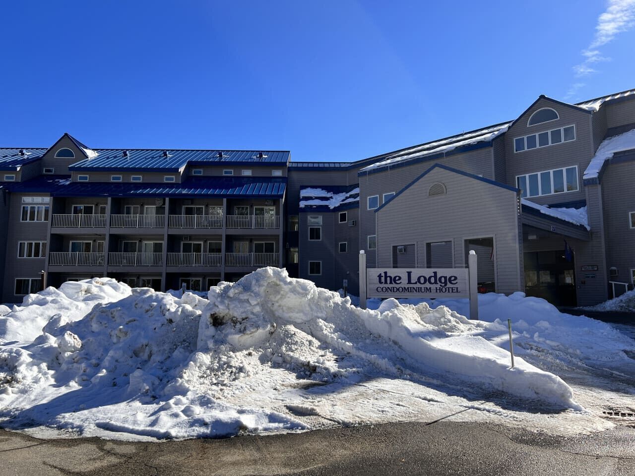 A snow-covered outdoor area with a sign for 'The Lodge Condominium Hotel'.