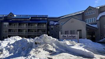 A snow-covered outdoor area with a sign for 'The Lodge Condominium Hotel'.