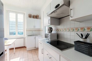 Apartamento luxo, sacada | Cozinha privada | Geladeira, micro-ondas, fogão, cooktop