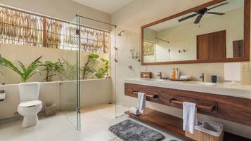 Un bagno moderno con cabina doccia in vetro, uno specchio grande e un mobile vanitario in legno.