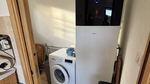 A compact laundry room with a washing machine, a dryer, and a trash bin. - Charming 4‑star classified house – Provence, stunning view, private pool (Rustrel)