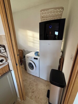 A compact laundry room with a washing machine, a dryer, and a trash bin. - Charming 4‑star classified house – Provence, stunning view, private pool (Rustrel)