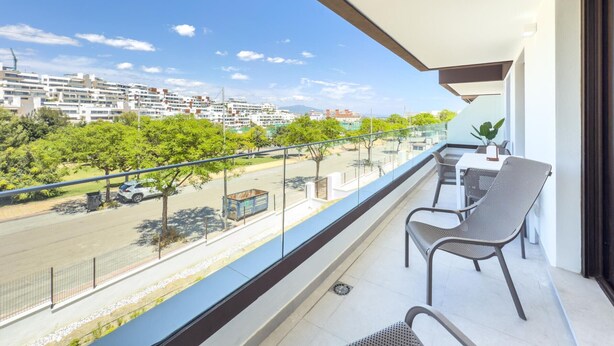 A balcony with a view of a residential area, a street, and a clear sky. - Modern and bright apartment near Estepona beach and center (Estepona)