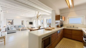 Una cucina moderna con una grande isola, mobili in legno e vista sull'esterno.