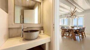 Un bagno moderno con una vasca freestanding, uno specchio grande e un mobile vanitario in legno.